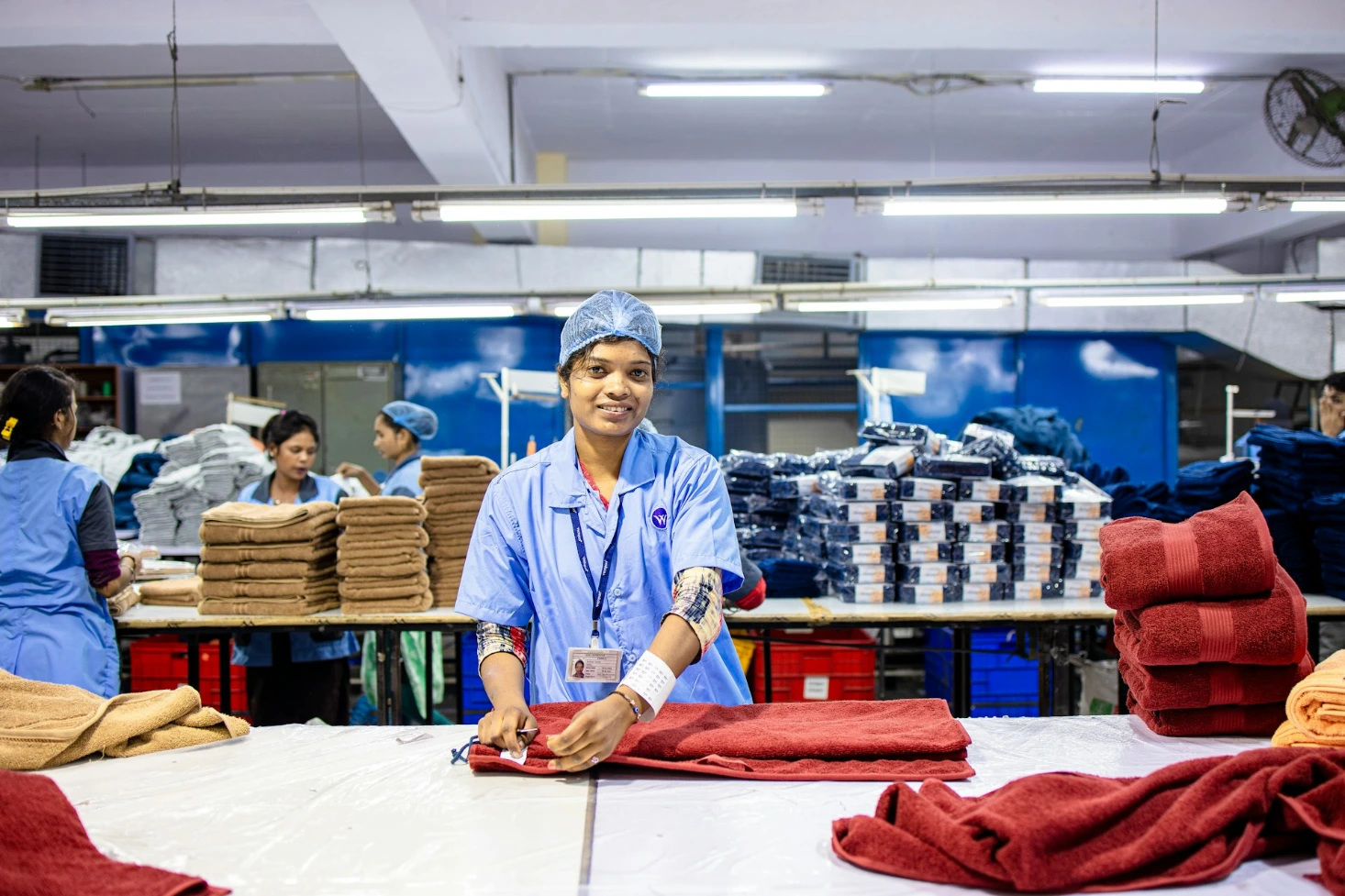 Happy worker Workers fold towels in a factory setting
